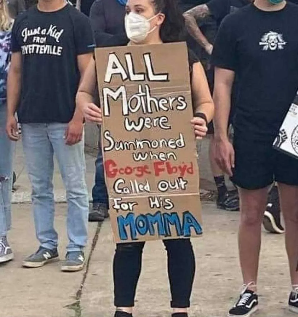 Black Lives Matter Protesters with sign saying "All mothers were summoned when George Floyd called out for his momma"