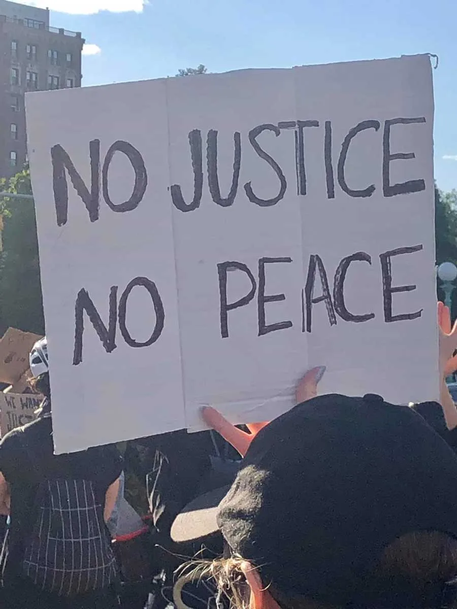Protest with siggn saying "No justice no peace"