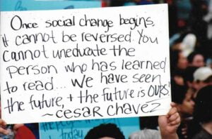 Person holding sign with Cesar Chavez quote